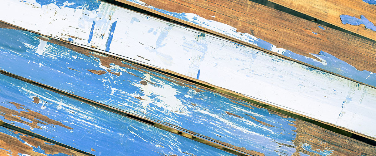 panel viejo hecho de listones de madera azul que están perdiendo la pintura